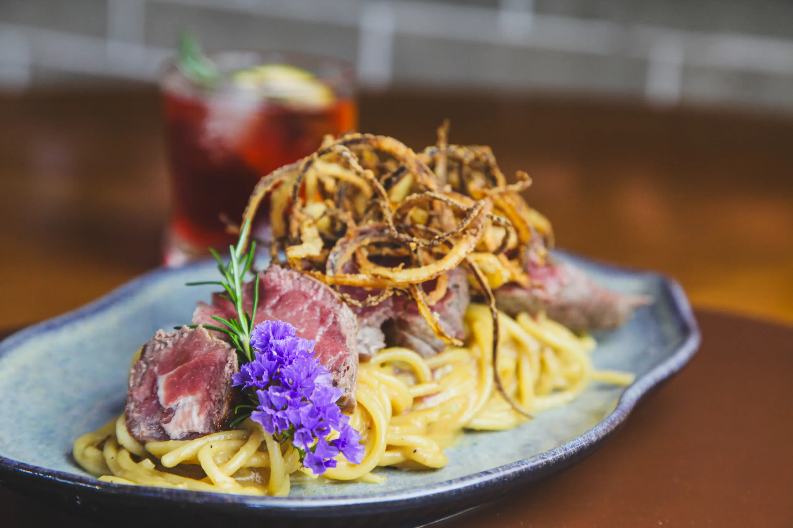 Spaghetti com filé mignon malpassado e cebola crocante no Fratelli Wine Bar