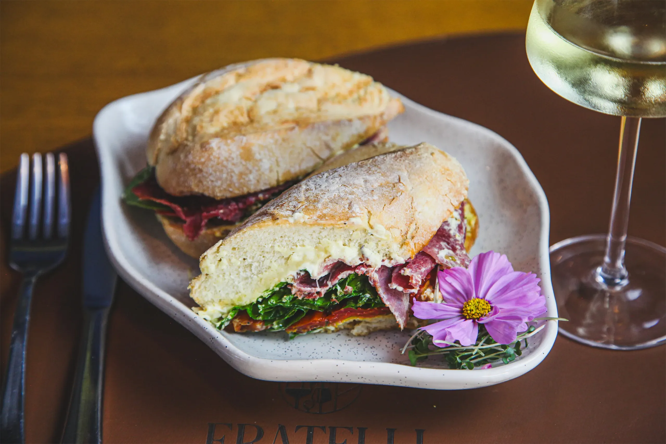 Sanduíche artesanal com vinho branco servido no Fratelli Wine Bar