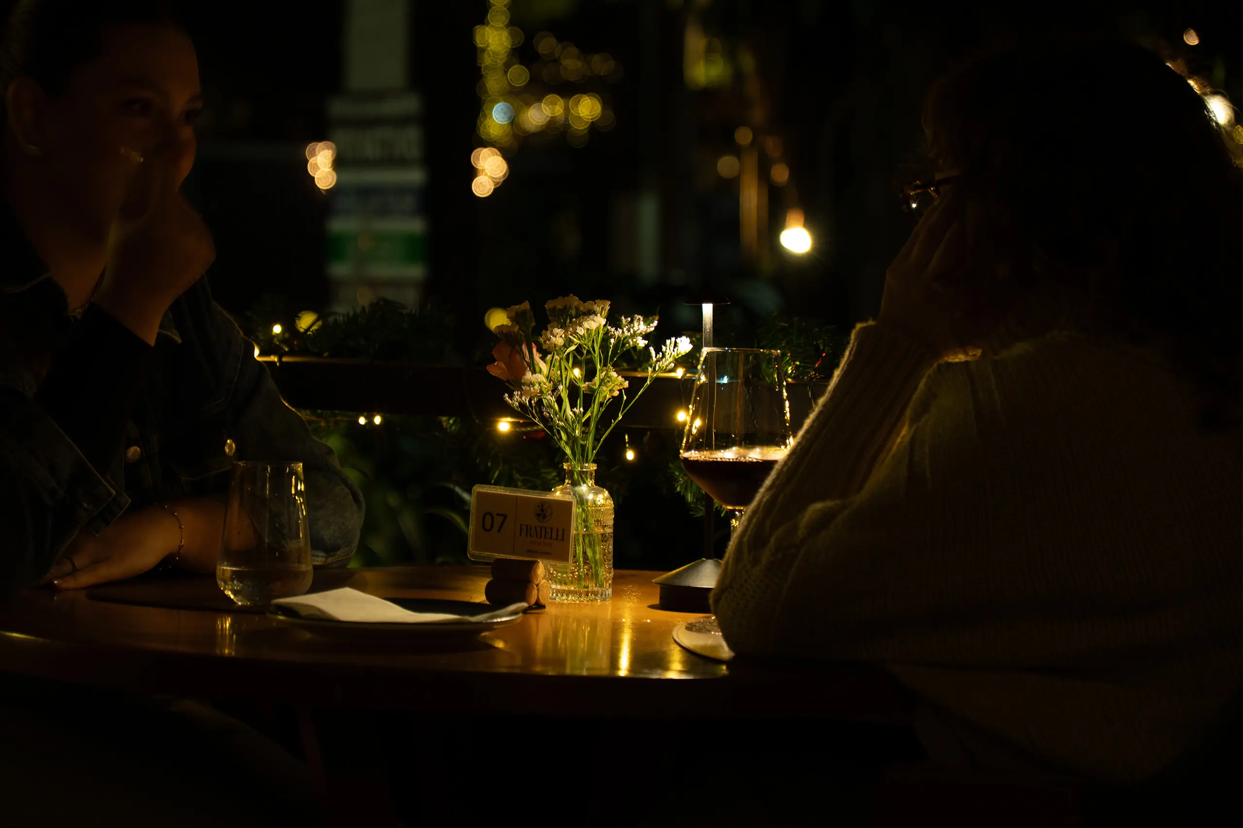 Duas pessoas em jantar à luz de velas com vinho tinto no Fratelli Wine Bar em Holambra