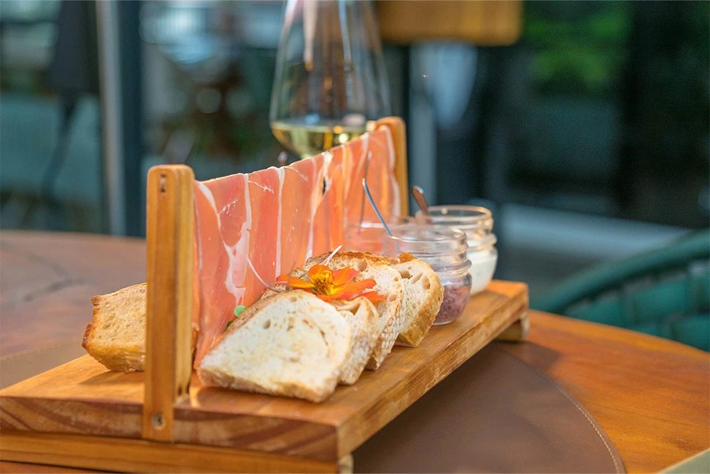 TÁBUA FRATELLI Presunto parma, fatias de pão de fermentação natural, tapenade de azeitona preta e azapa, creme de gorgonzola com geleia de jabuticaba, cream cheese com tartar de tomate e manjericão, tomate seco artesanal e caponata de berinjela.